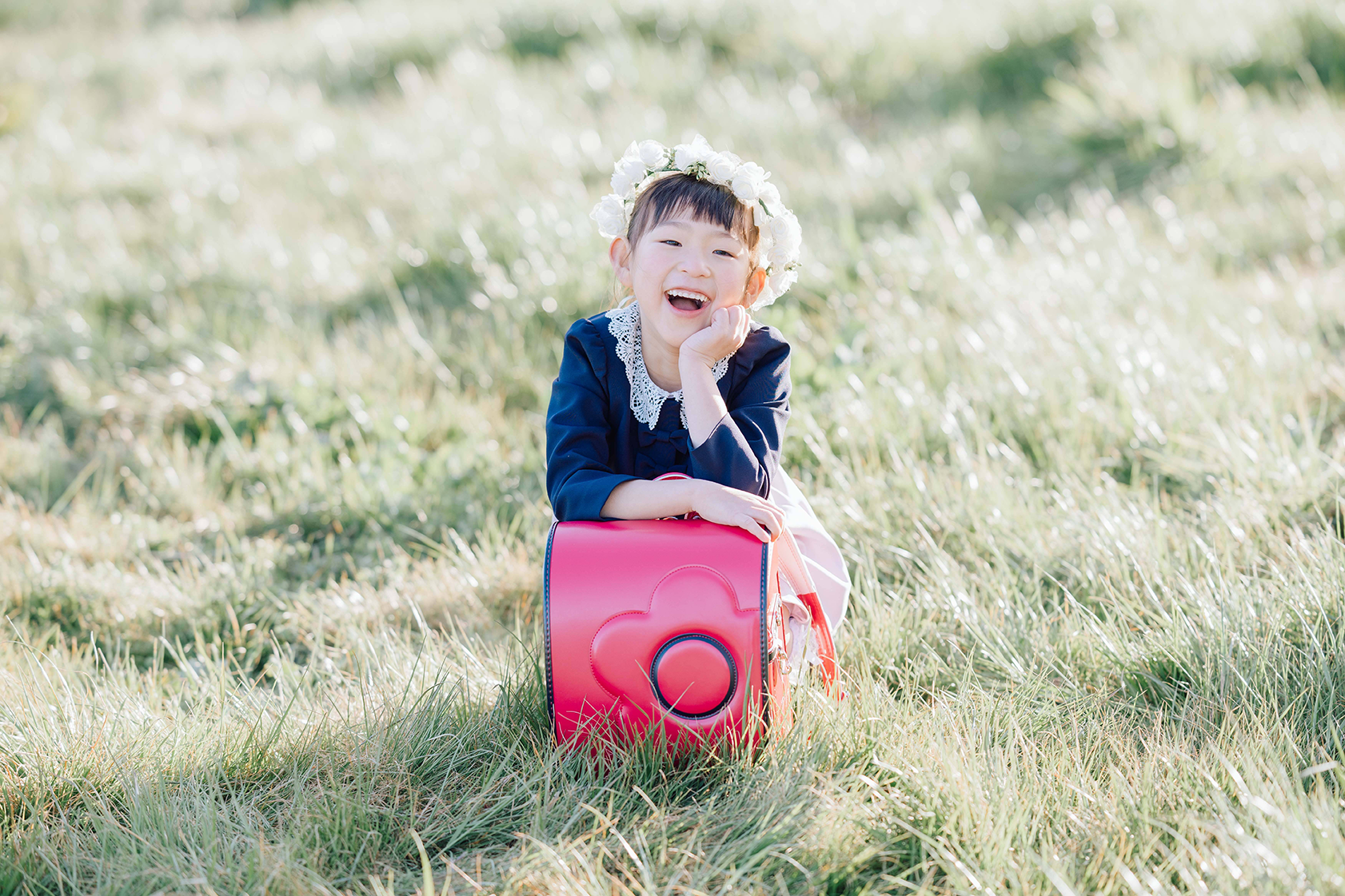 ピンクのランドセルに嬉しそうにもたれる女の子