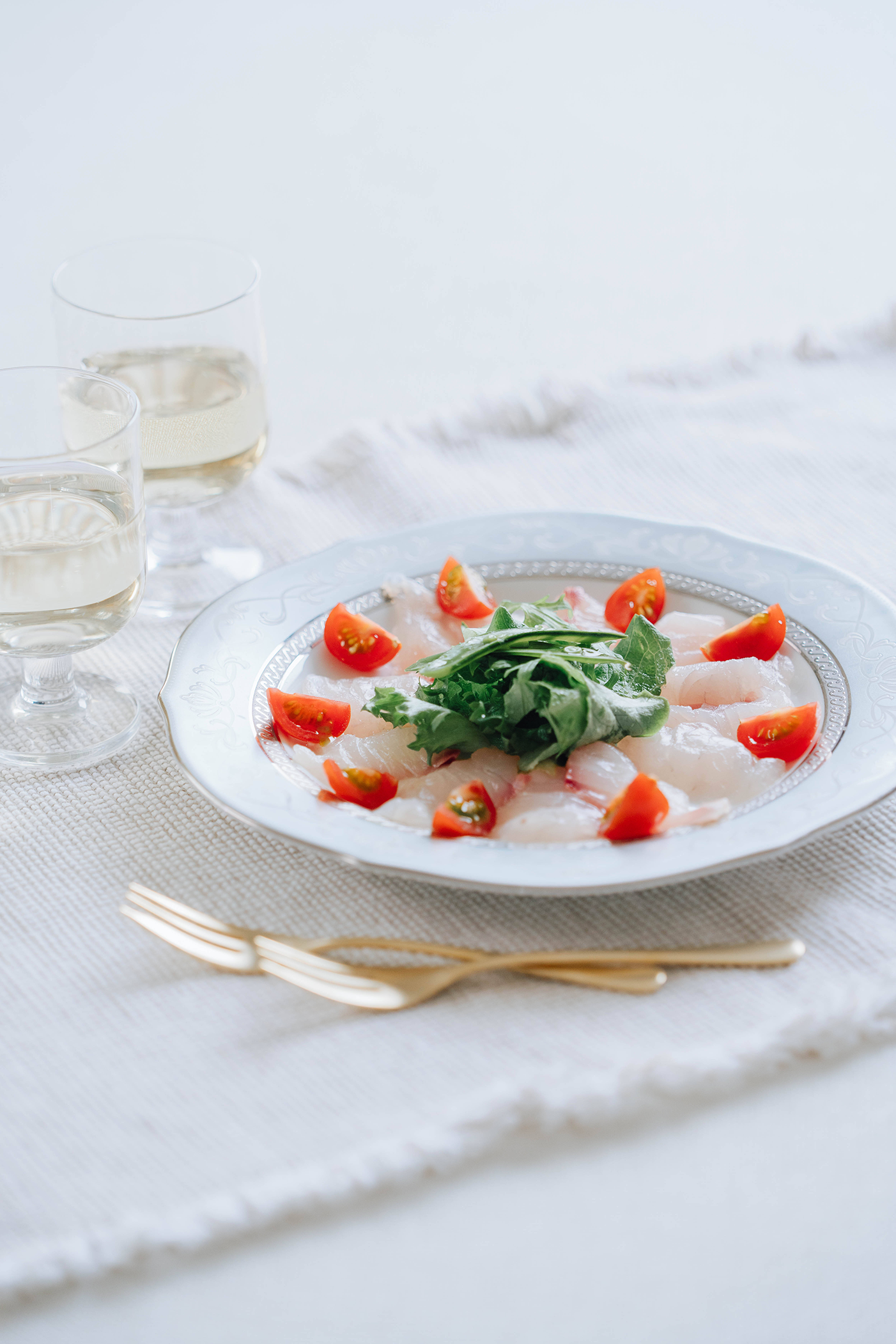 料理写真　レストランの真っ白なテーブルに映える戦後のカルパッチョ