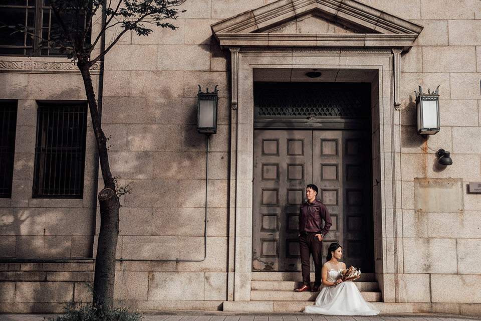 レトロな他建物の前で座るカップル