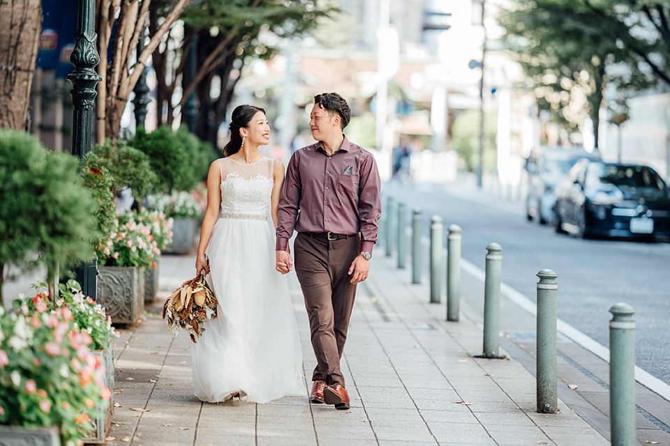 街中をウエディングドレスで歩くカップル